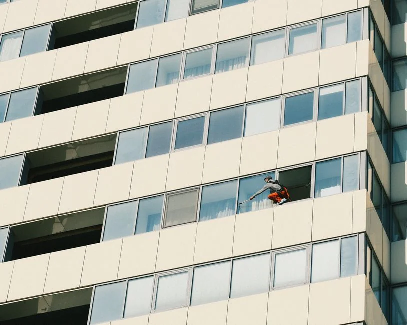 services-04 Urban worker cleaning windows on a high-rise in Ho Chi Minh City, Vietnam.